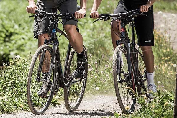 two cyclists riding a country track