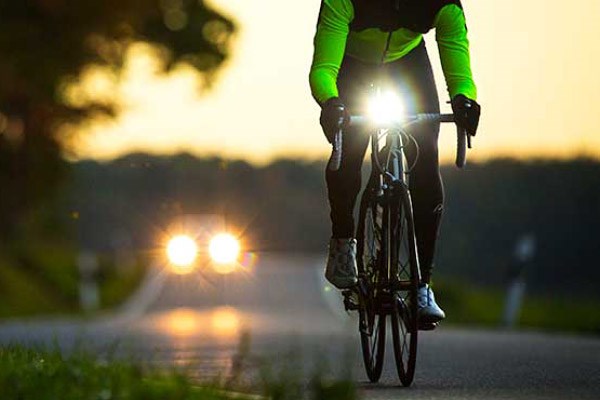 Cyclist on the road at night with lights