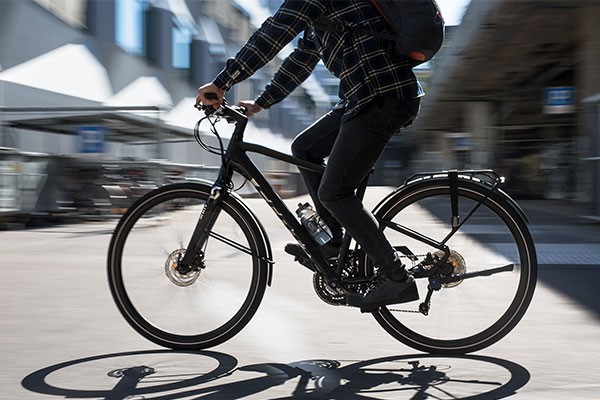 Urban cyclist riding a black hybrid bike in the city