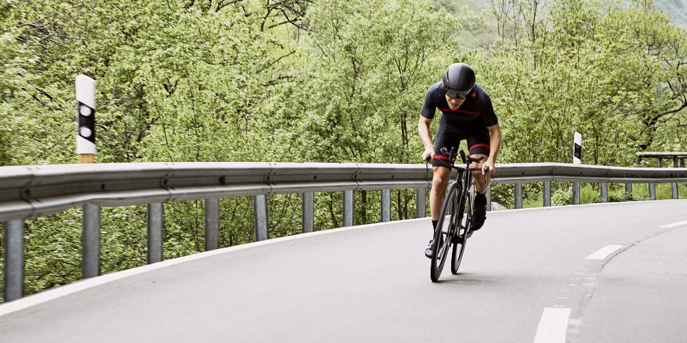 A cyclist on an empty road, riding a BMC Triathlon Bike