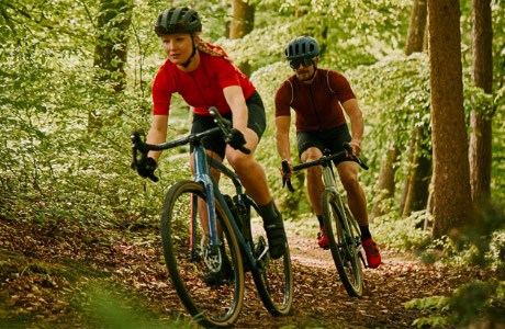 Two cyclists riding through forest trails on the BMC Unrestricted