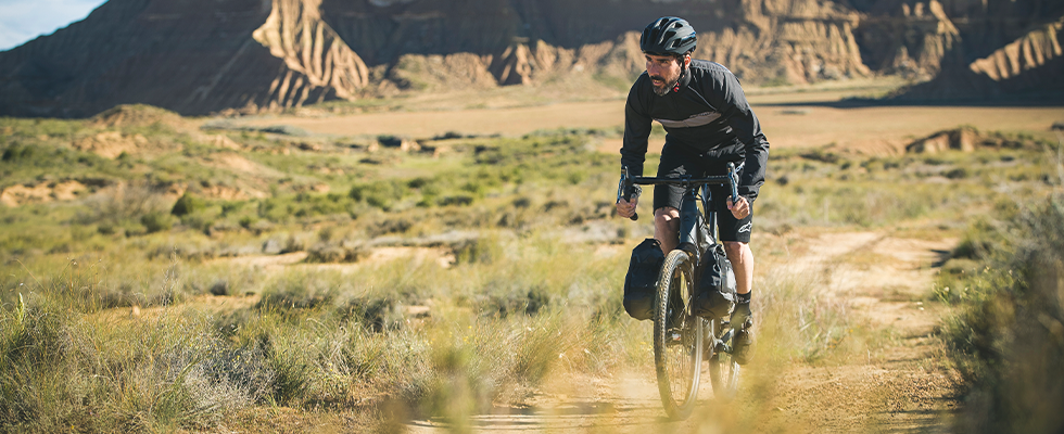 A cyclist riding along a dirt path on the Merida Silex