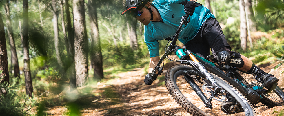 A mountain biker riding through woodland on the Merida eOne Sixty electric Mountain Bike