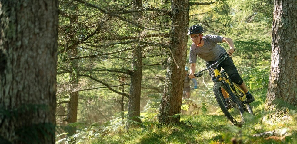 MTB rider descending through the woods on Orbea Wild FS in Spain