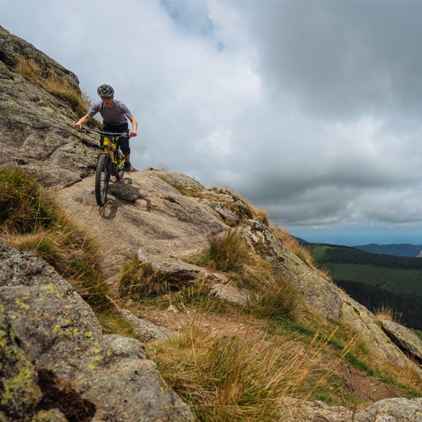 MTB rider descending over rocks on an Orbea Wild FS in Spain