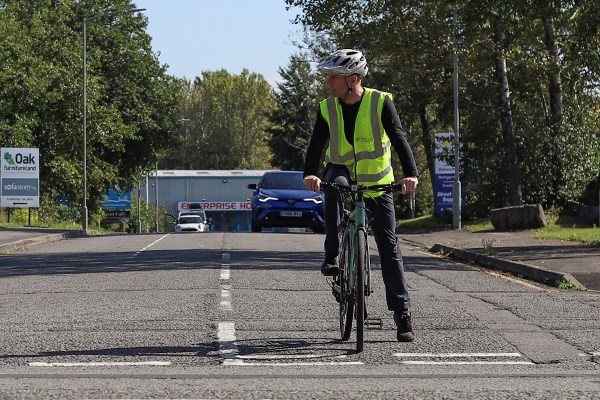 cyclist waiting to turn right onto a main road