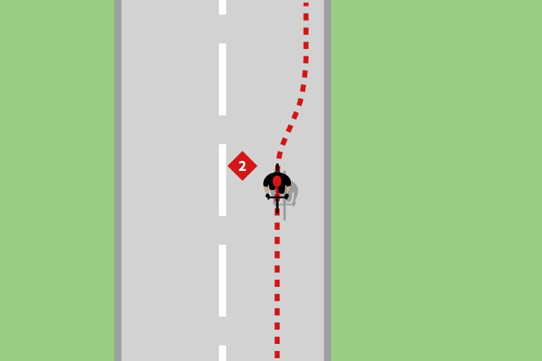 A cyclist turning left onto a main road