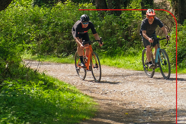 Gravel cyclists riding through a forest