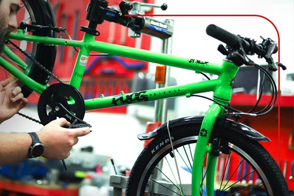 A Frog kids bike being assembled by a Tredz Mechanic