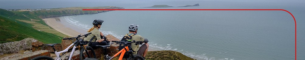 Two mountain bikers overlooking Rhossili Bay