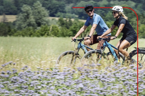 Two cyclists riding electric bikes along a cycle path