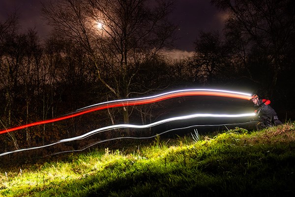 MTB rider with helmet and handlebar light trails