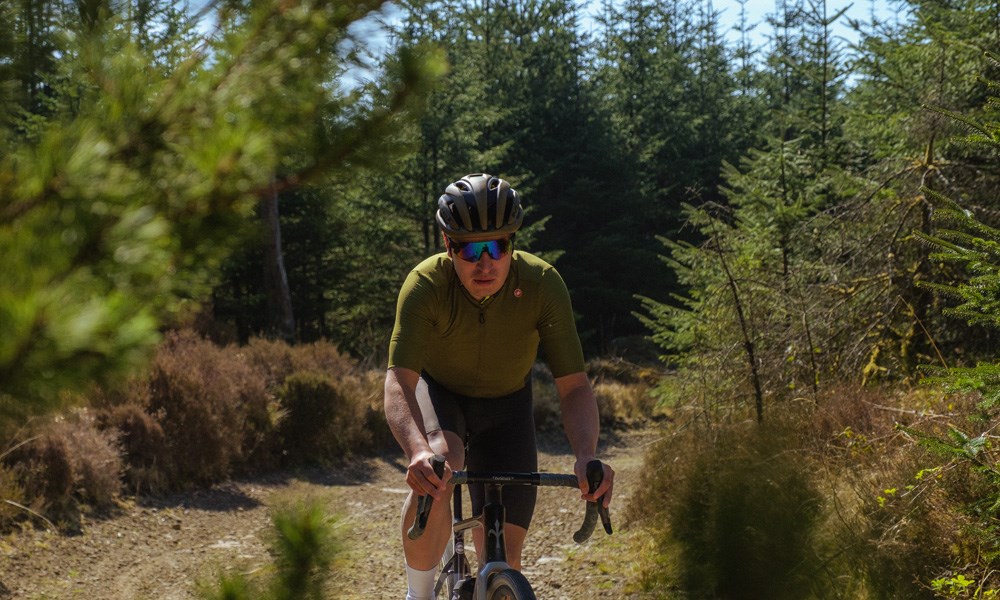 two gravel riders raiding fast on a warm day in Wales - pan shot