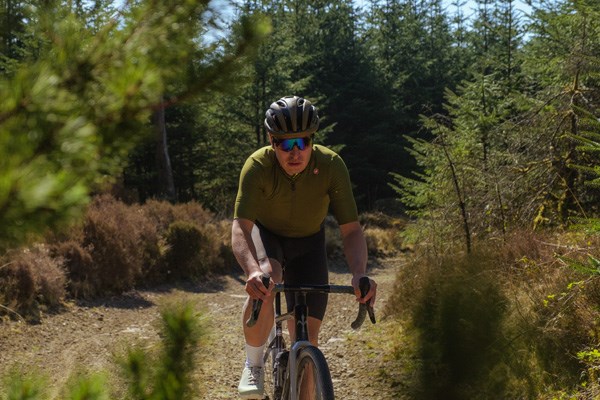 two gravel riders raiding fast on a warm day in Wales - pan shot