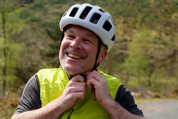 man putting on a Poc helmet
