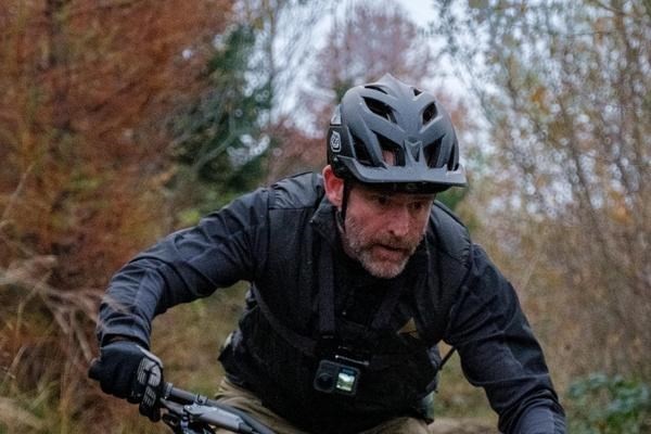 riding a mountain bike descent wearing a Troy Lee helmet and Go-Oro chest mount