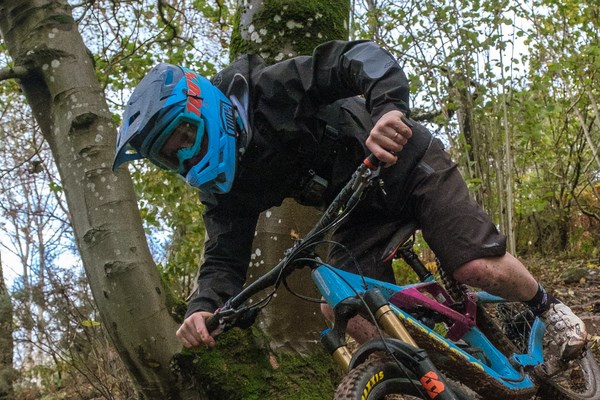 Mountain biker descending a gnarly trail wearing a full face helmet and goggles