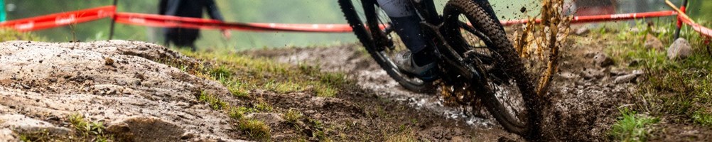 MTB DH racer splashing through puddle