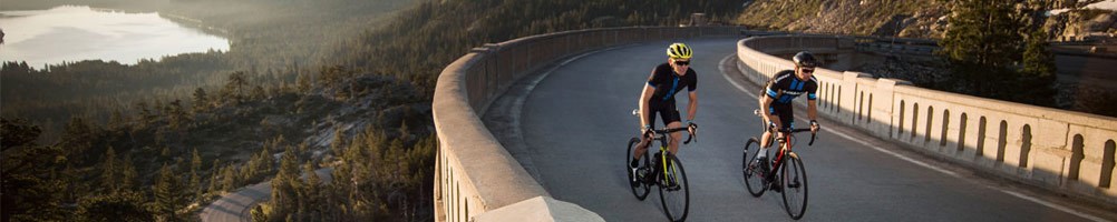 Two road cyclists ascending a hill