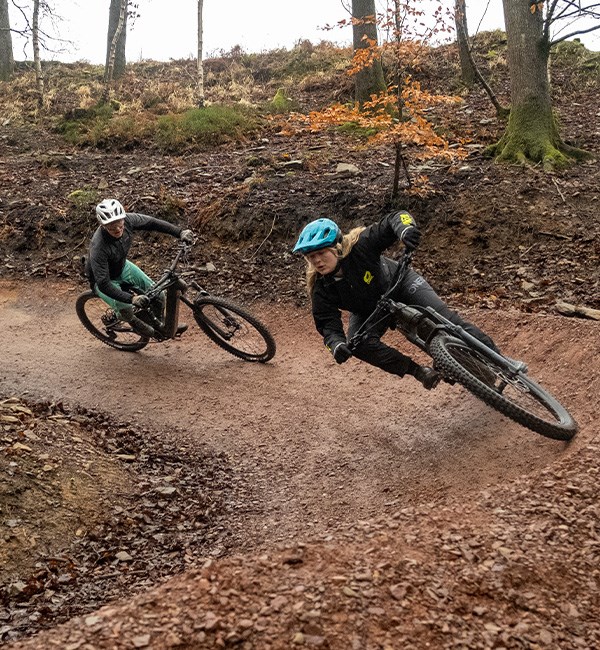 woman and man riding merida eone-sixty e-bikes offroad