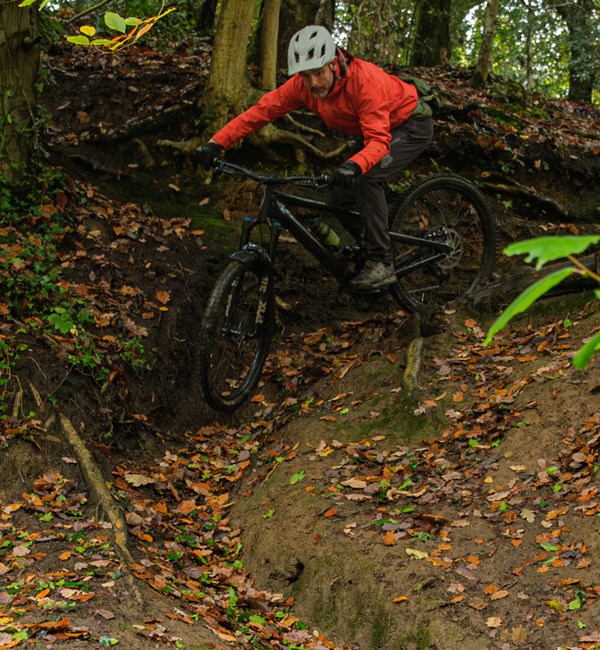 Mountain biker riding a Specialized Kenevo SL on technical terrain