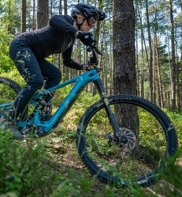 female mountain biker riding downhill on Yeti ebike with FOX Podium fork