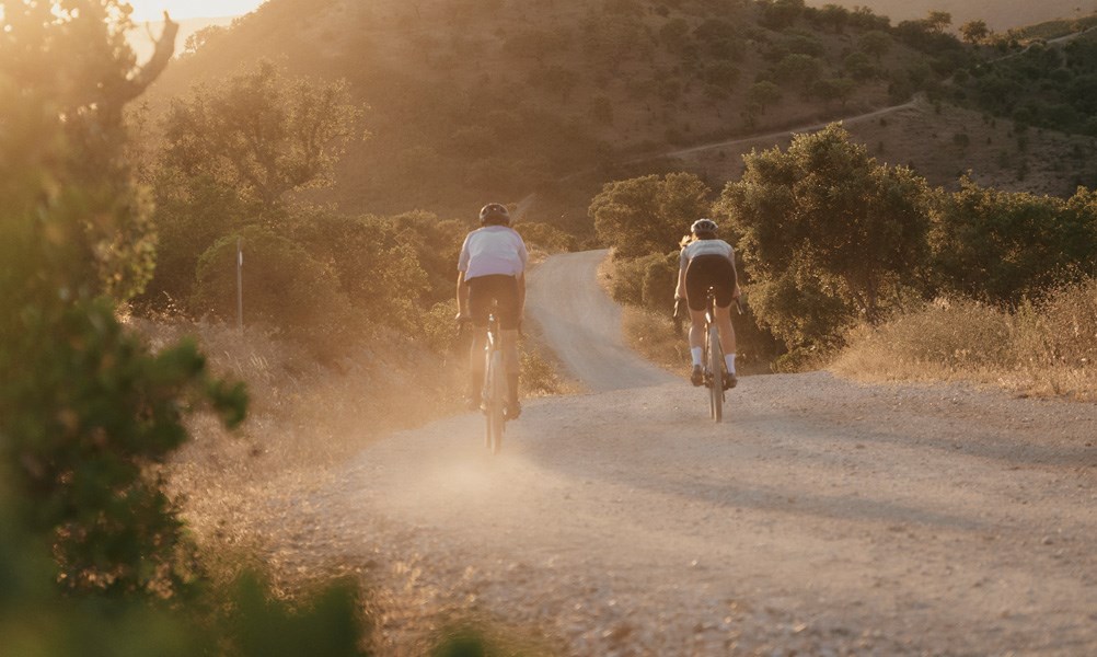 gravel riders cycling into the sunset