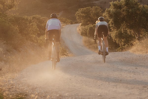 gravel riders cycling into the sunset