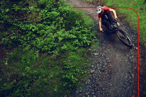 Mountain biker descending steep grassy section