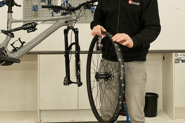 checking tubeless ready rim tape on an mtb wheel