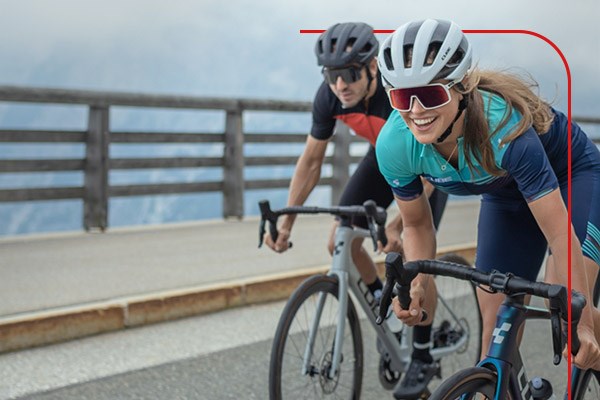 Road cyclists riding over a bridge in misty weather