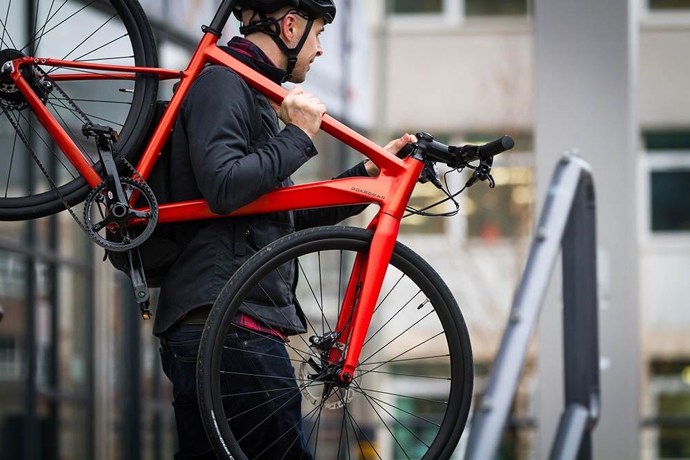 commuter with bike on shoulder