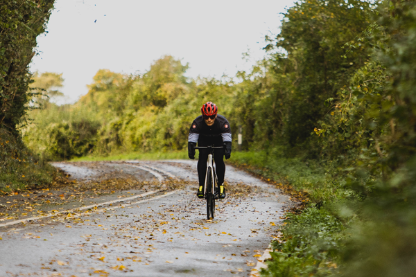 A cyclist riding along an autumnal cycle path