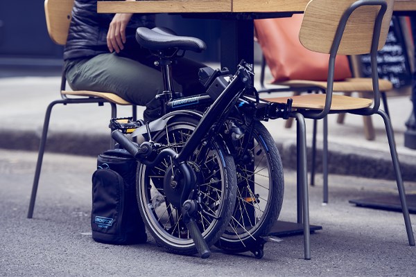 Brompton electric folding e-bike folded under a table