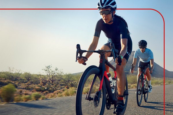 Two road cyclists riding along a rural road