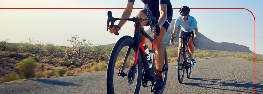 Two road cyclists riding along a rural road