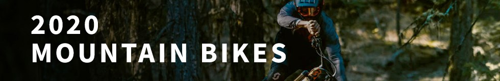 A mountain biker hitting a jump on a 2020 Scott MTB