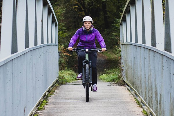 A cyclist riding across a bridge on an Ebike