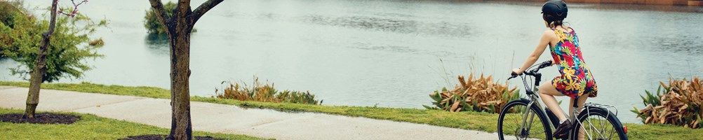 female biker cycling by the river